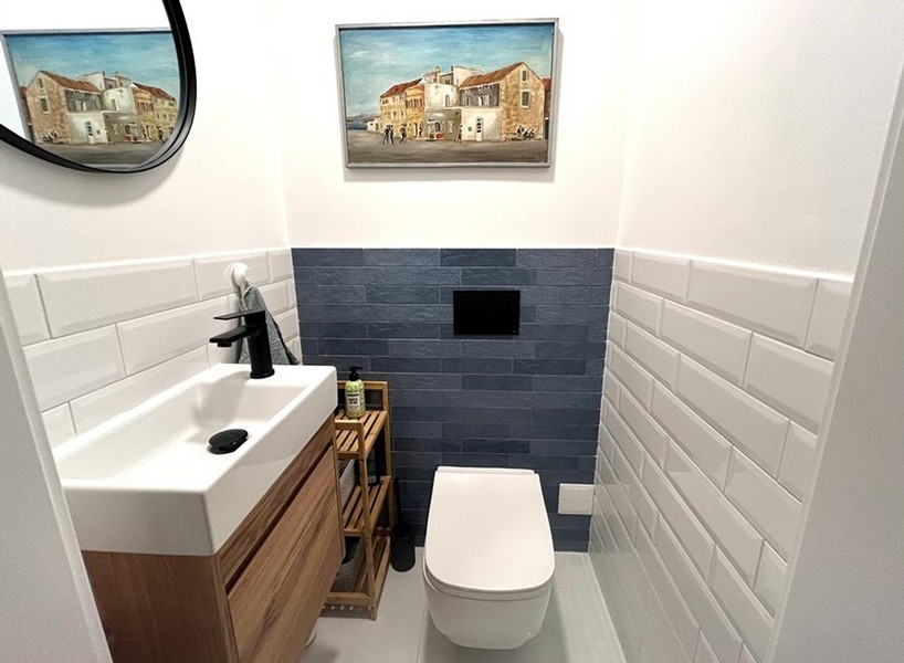 WC séparé avec lavabo et carrelage mural