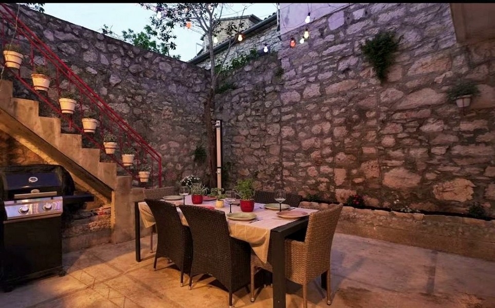 Cour intérieure avec mur en pierre naturelle et coin salon extérieur