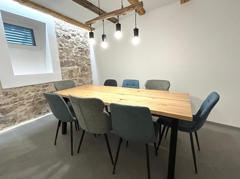 Coin repas couvert à l'intérieur avec poutres en bois et éclairage