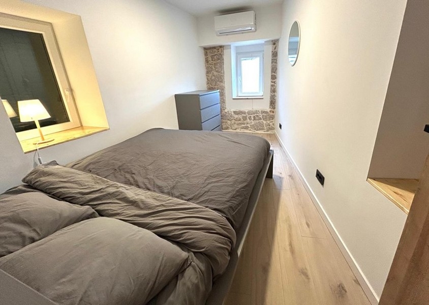 Chambre avec lit double et mur en pierre naturelle apparent