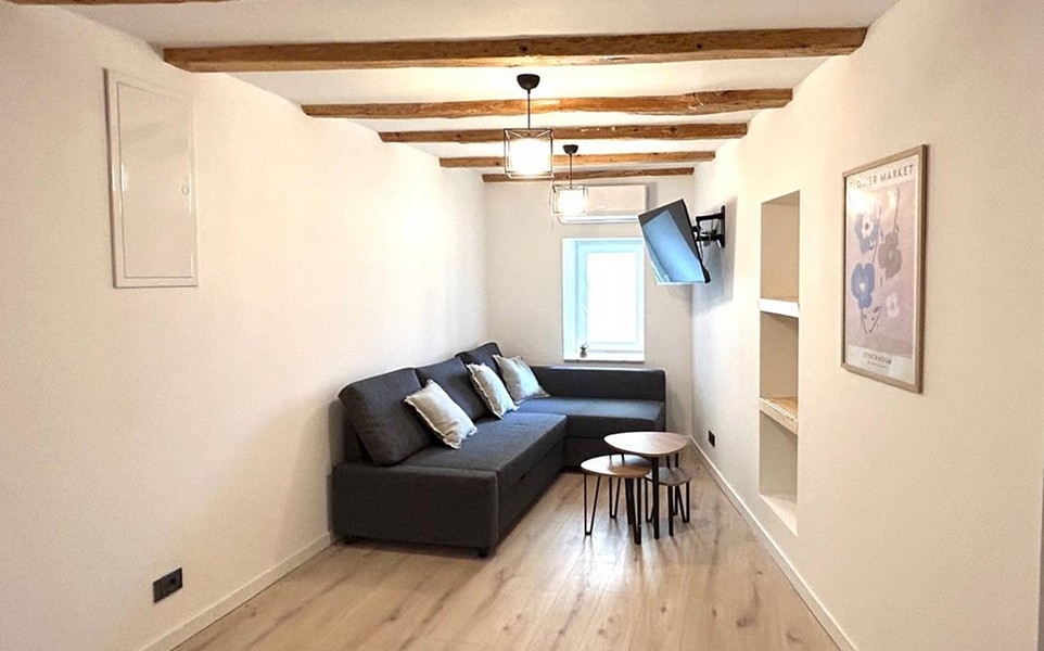 Séjour avec canapé et plafond à poutres en bois