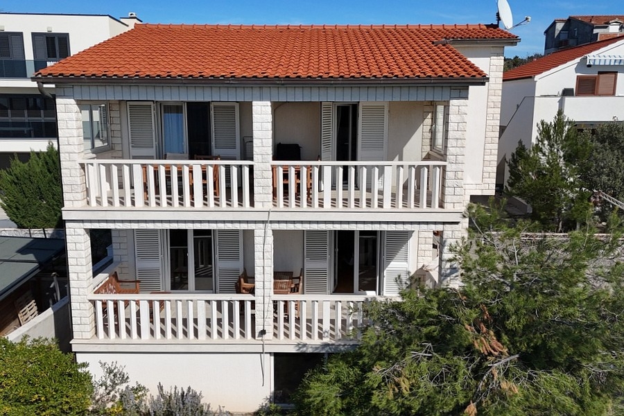 Vue de la maison avec terrasses et toit de tuiles rouges près de la côte