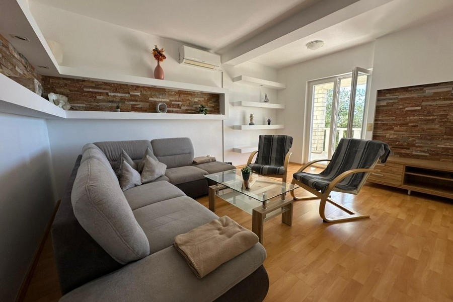 Salon avec canapé, fauteuil et aménagement mural moderne