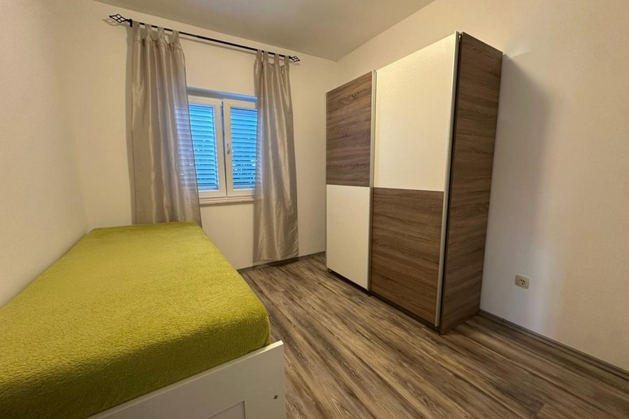 Chambre avec lit simple et penderie à l'aménagement clair
