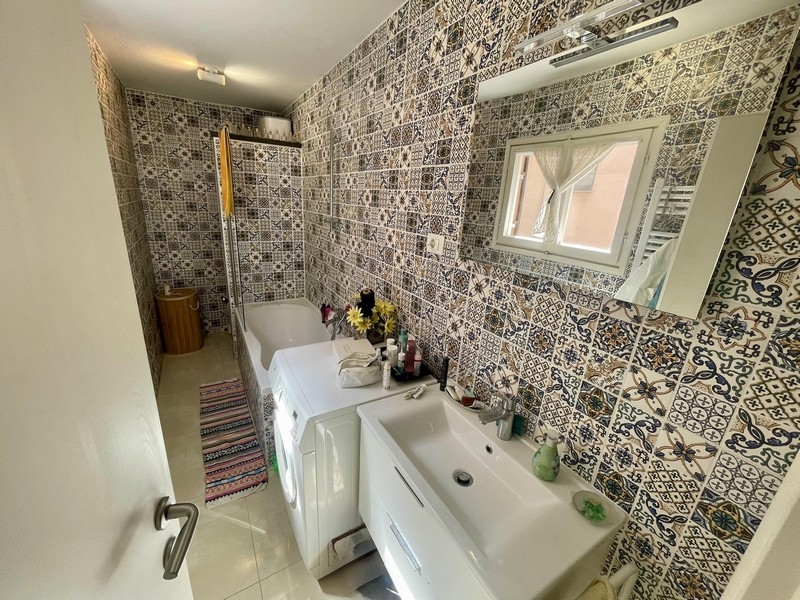 Salle de bains avec baignoire et lave-linge
