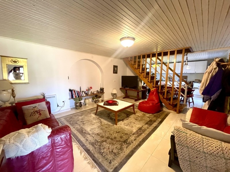Salon avec canapé, tapis et escalier ouvert