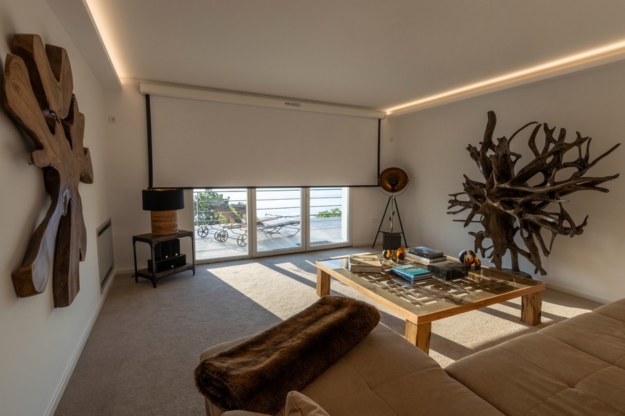 Salon avec grandes baies vitrées et vue mer