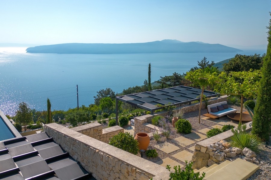 Jardin avec murs en pierre naturelle et vue mer