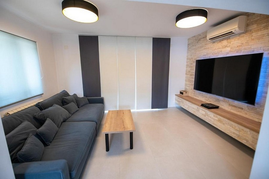 Salon avec grand écran TV et aménagement mural moderne
