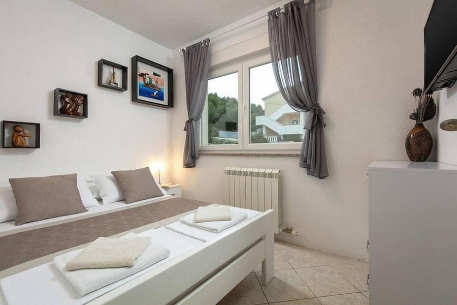 Chambre avec lit double et fenêtre donnant sur la verdure