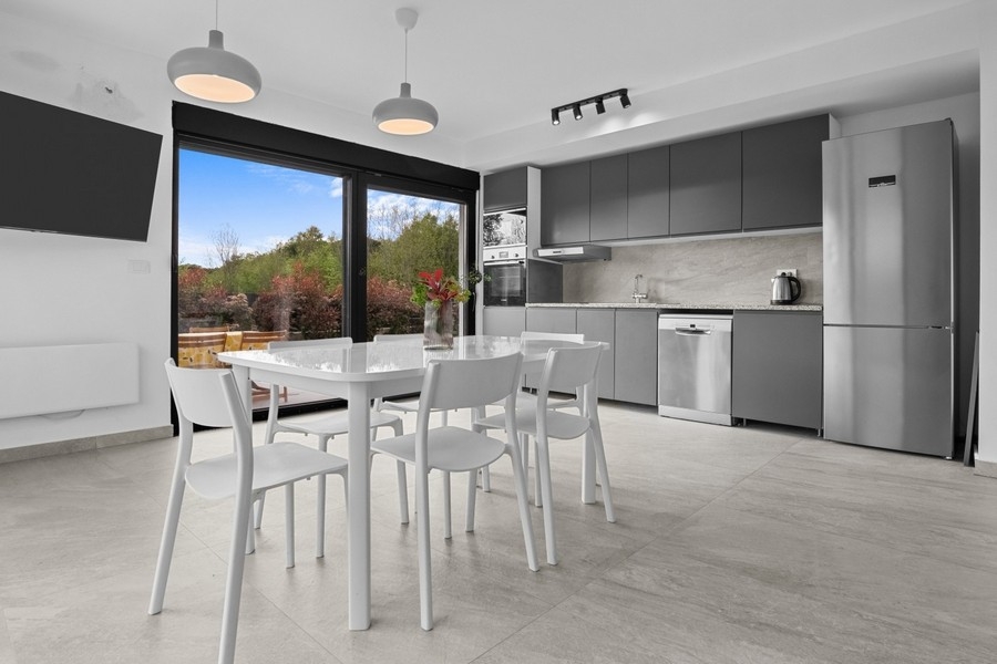 Séjour et coin repas modernes avec cuisine ouverte et accès à la terrasse