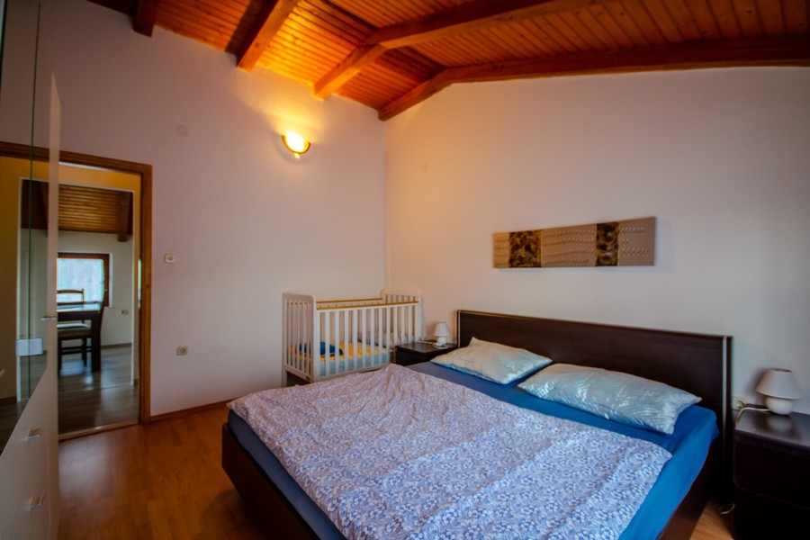 Chambre avec lit double et plafond à poutres en bois