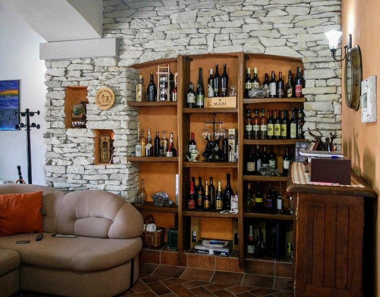 Séjour avec mur en pierre naturelle et cave à vin intégrée