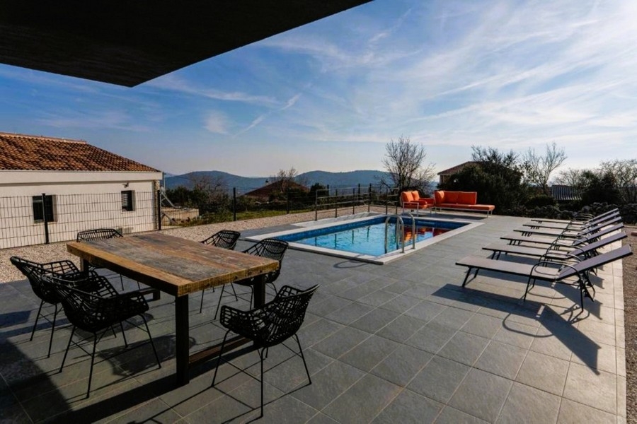 Terrasse avec piscine et vue sur les montagnes.