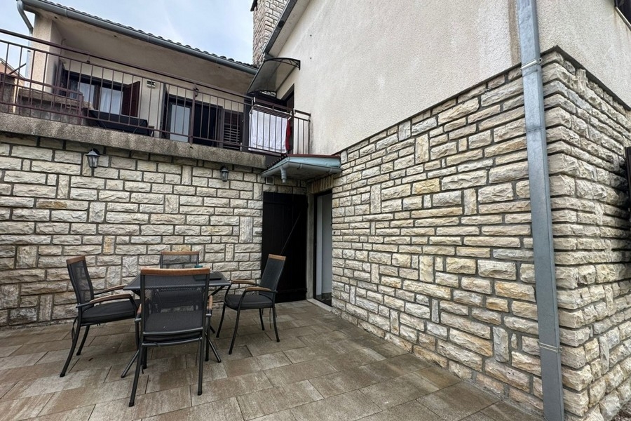 Cour intérieure avec façade en pierre et terrasse avec coin salon