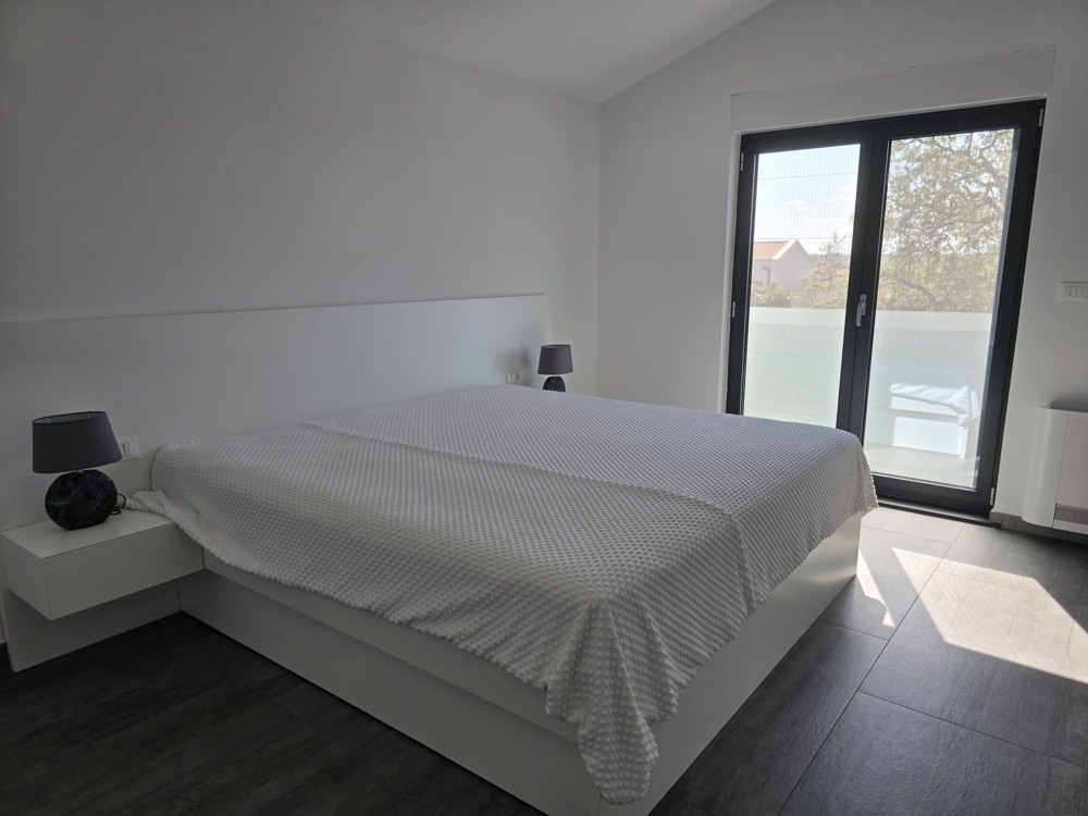 Salon lumineux avec grande baie vitrée et accès à la terrasse