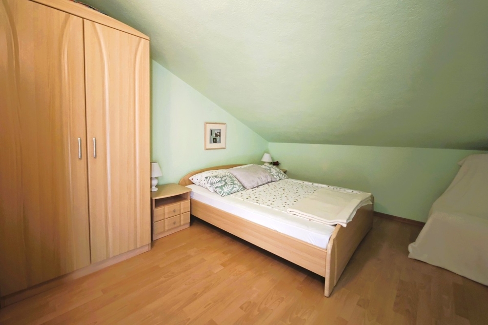 Chambre sous les combles avec mur en pente et lit simple