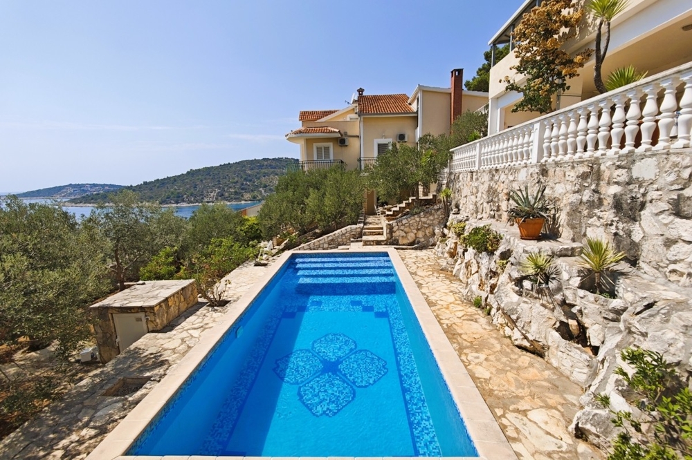 Piscine avec vue mer et terrasse en pierre naturelle