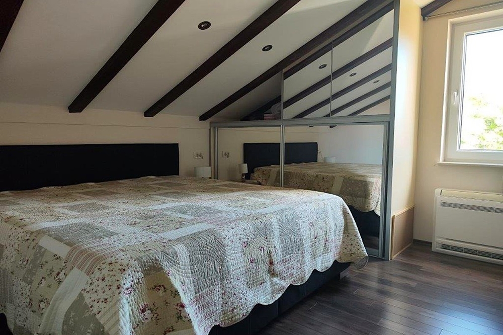 Chambre sous les combles avec poutres en bois apparentes
