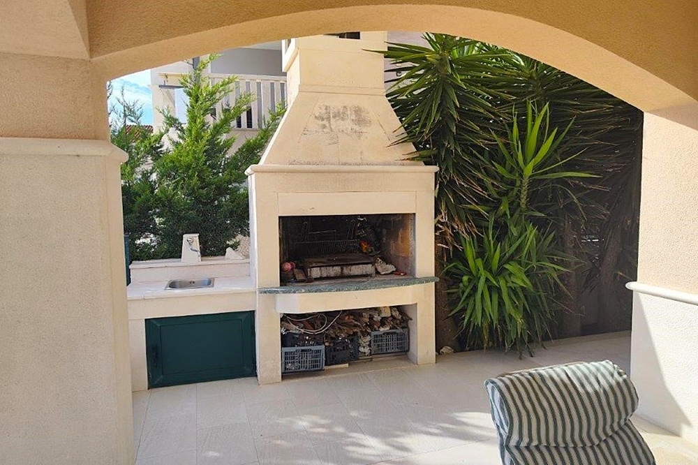 Terrasse couverte avec cheminée-barbecue et cuisine extérieure