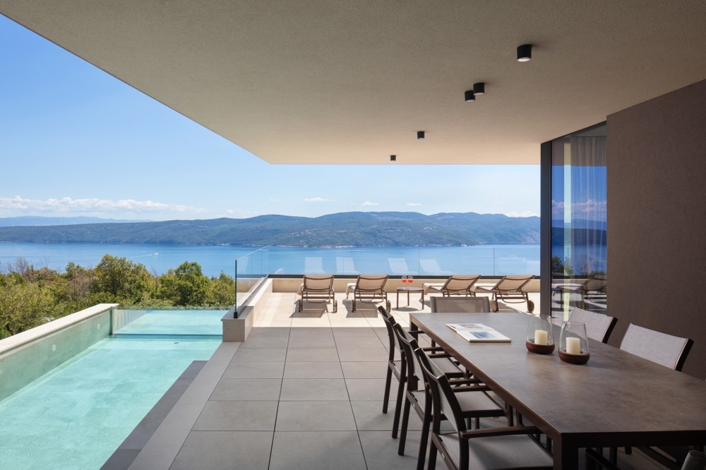 Terrasse couverte avec coin repas et vue mer