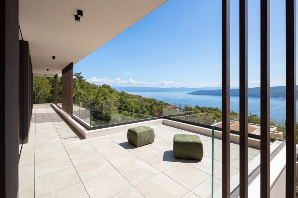 Vaste terrasse-balcon avec garde-corps en verre et vue mer