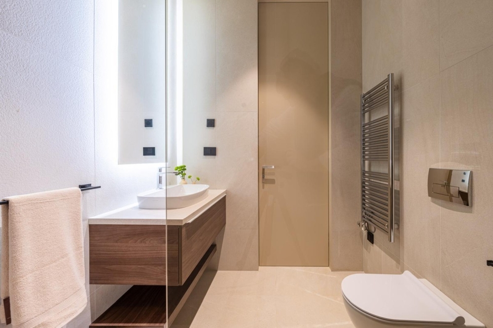 Salle de bains claire avec lavabo et radiateur sèche-serviettes