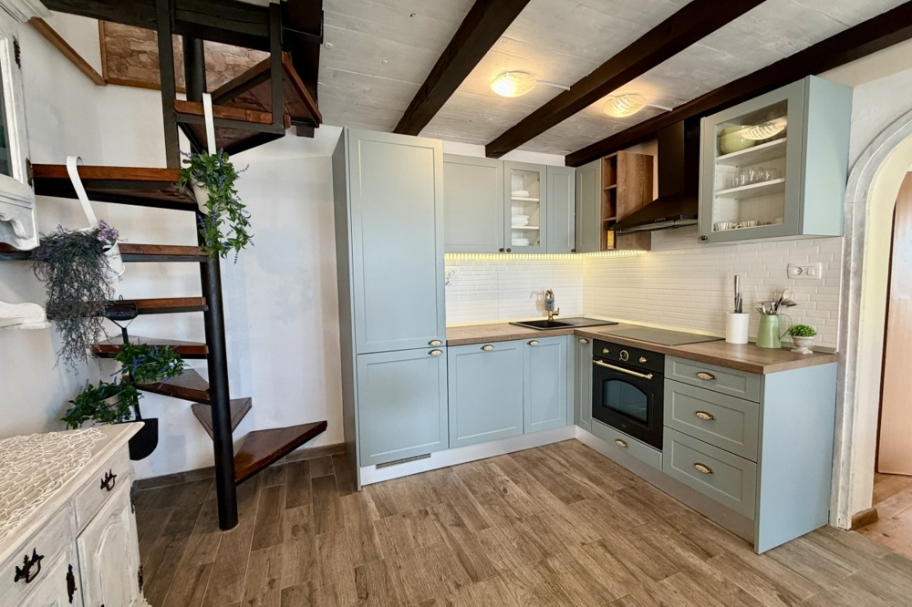 Cuisine ouverte avec meubles encastrés et escalier en bois
