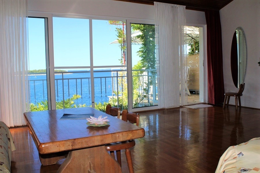 Séjour avec grandes baies vitrées et accès à la terrasse avec vue mer