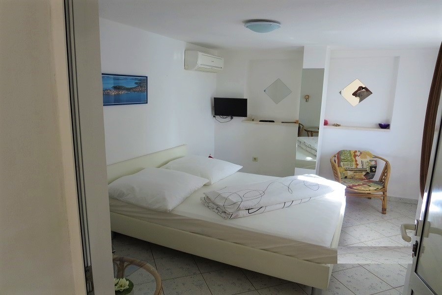 Chambre avec lit double, climatisation et équipement clair