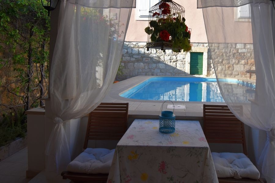 Coin repas couvert au bord de la piscine