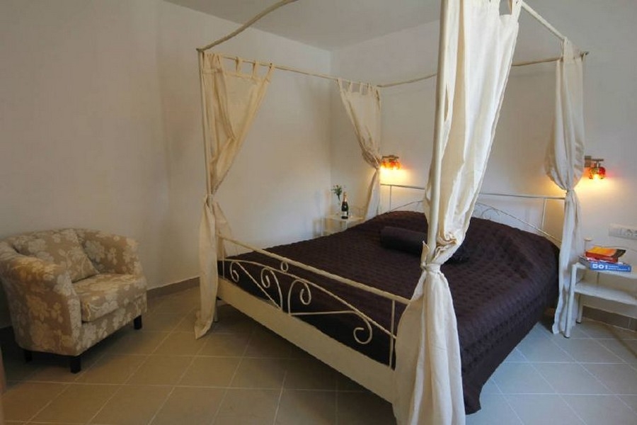 Chambre avec lit à baldaquin de style méditerranéen