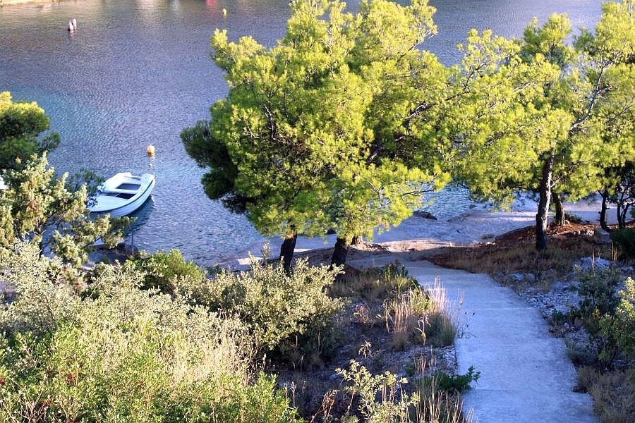 Chemin vers la plage avec bateau dans une baie calme