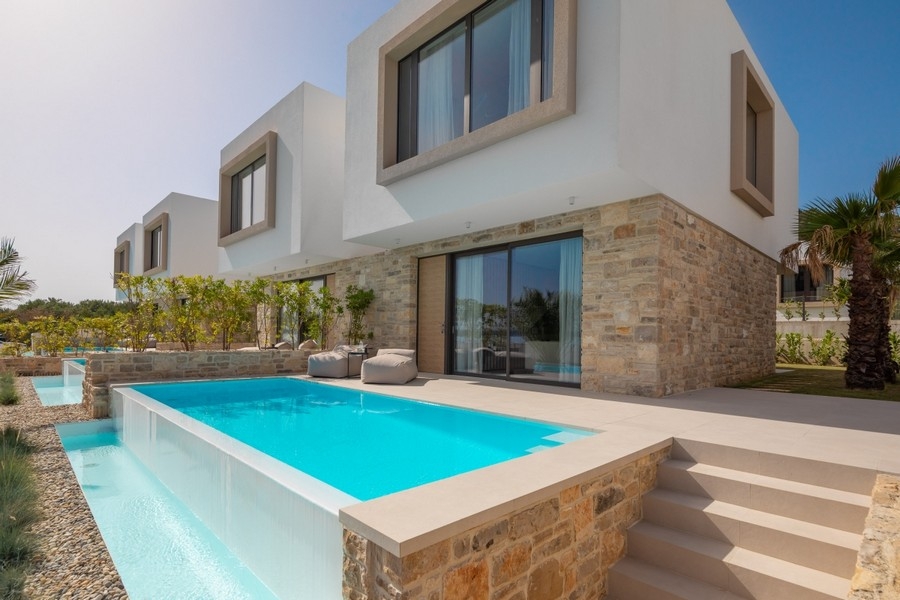 Piscine à revêtement en pierre naturelle devant la villa moderne