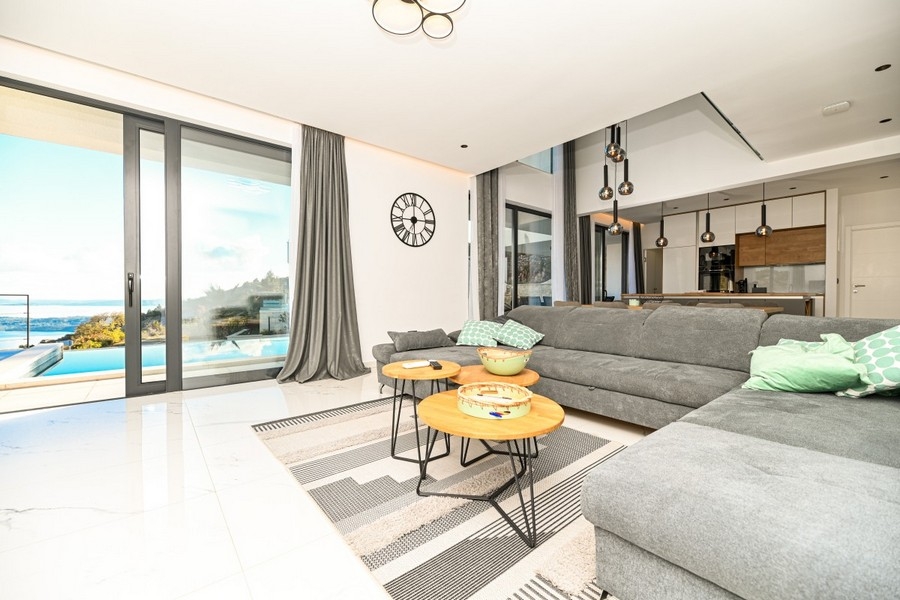 Salon avec grandes surfaces vitrées et vue sur la piscine