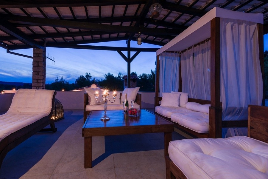 Espace lounge avec lit à baldaquin et vue sur la côte