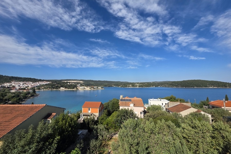 Vue sur les toits de tuiles et la vaste baie sous un ciel nuageux