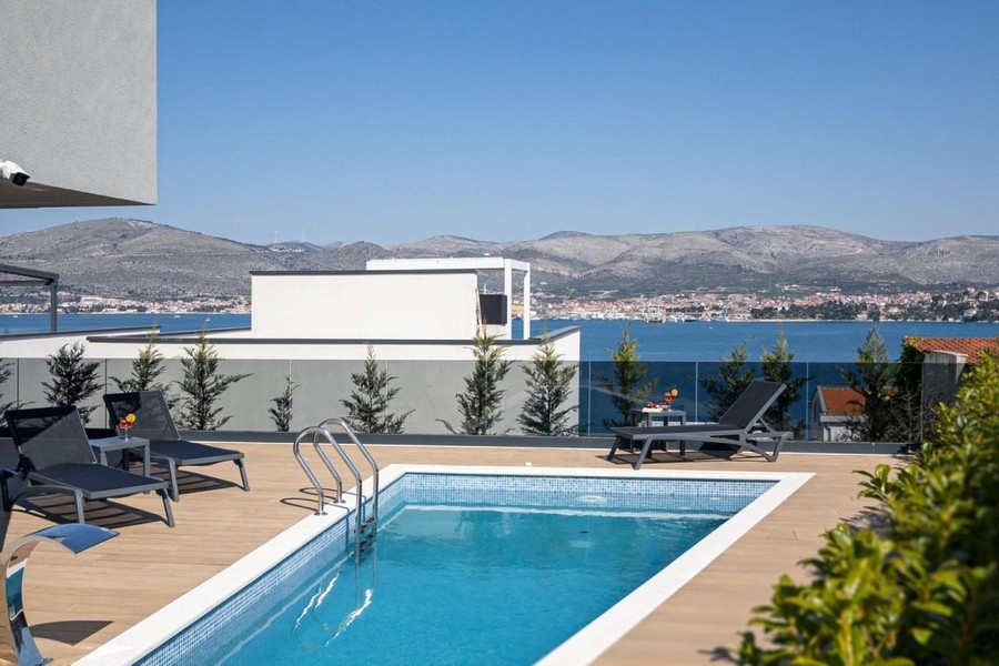 Vue sur la piscine et la mer depuis la terrasse de la maison en bande
