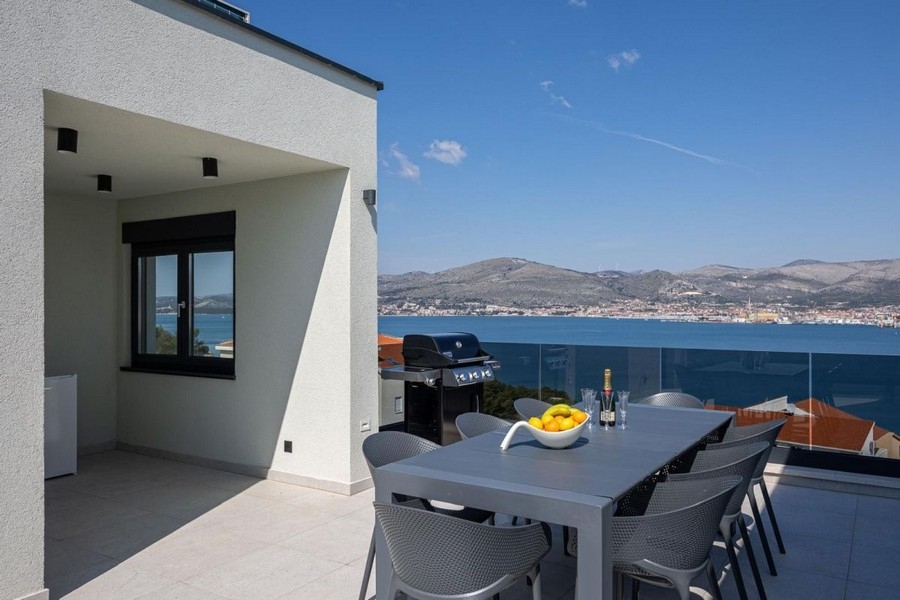 Terrasse couverte avec coin repas et vue mer