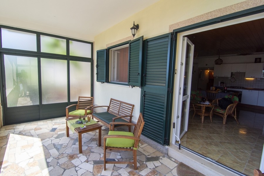 Terrasse couverte avec coin salon et accès au séjour
