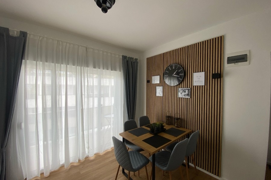 Espace repas à la décoration murale moderne et accès au balcon