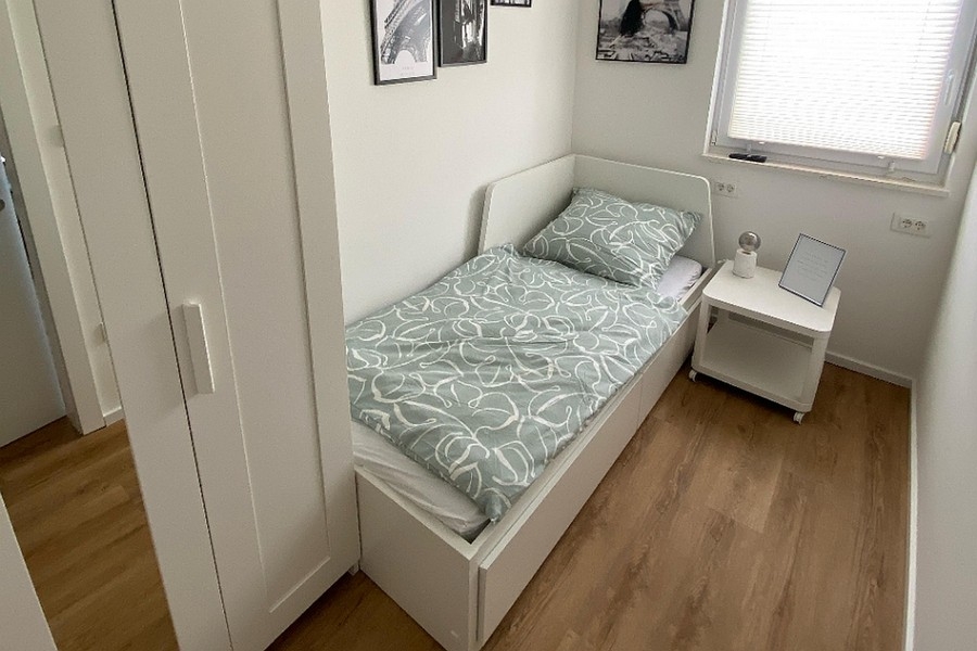 Petite chambre avec lit simple et armoire
