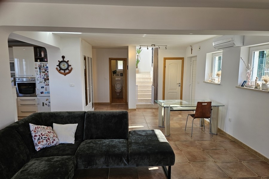 Coin salon avec table à manger en verre et vue sur l'escalier