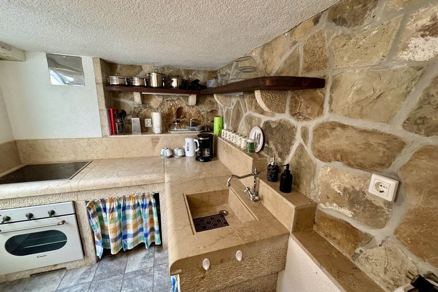 Cuisine rustique en pierre au caractère méditerranéen dans la maison de village rénovée