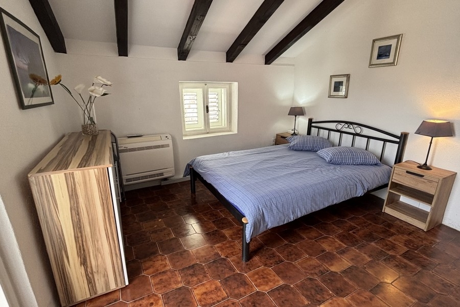 Chambre claire avec poutres en bois apparentes dans la maison en pierre dalmate