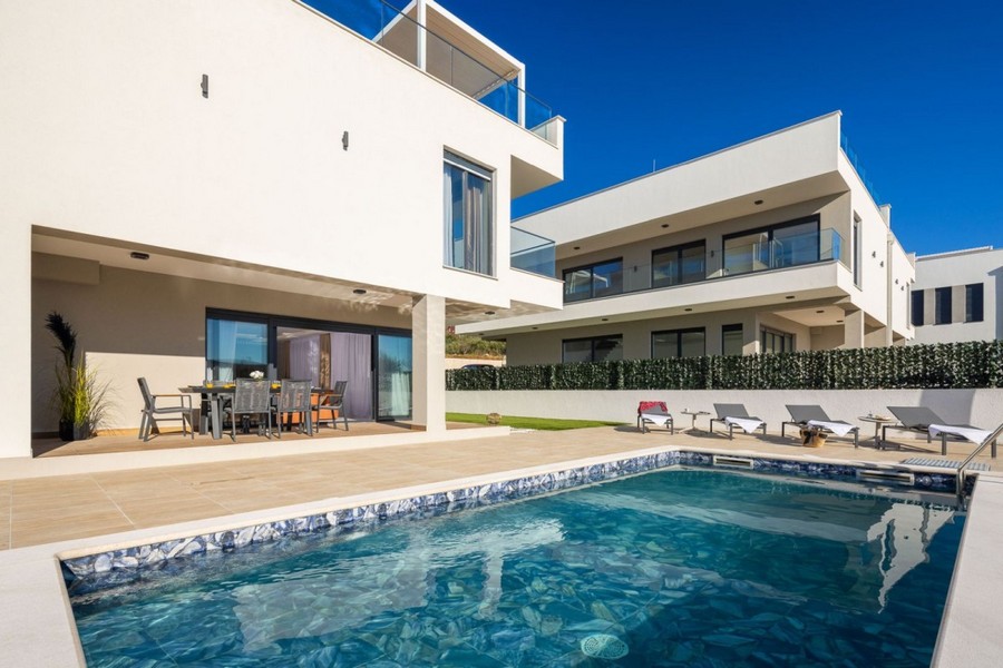 Piscine devant la maison avec bains de soleil