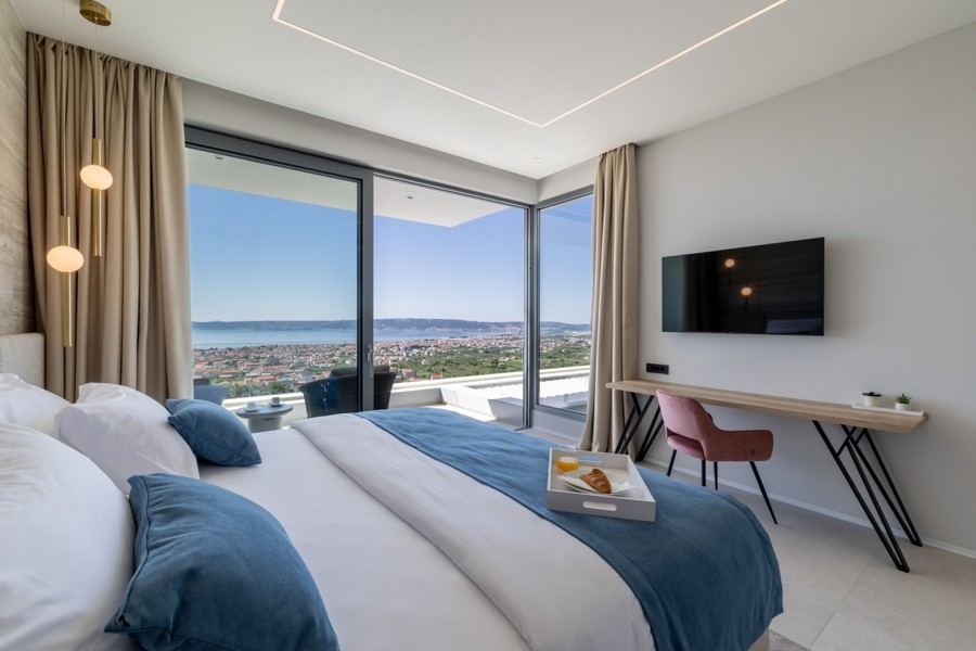Chambre moderne avec façade vitrée et panorama sur la côte