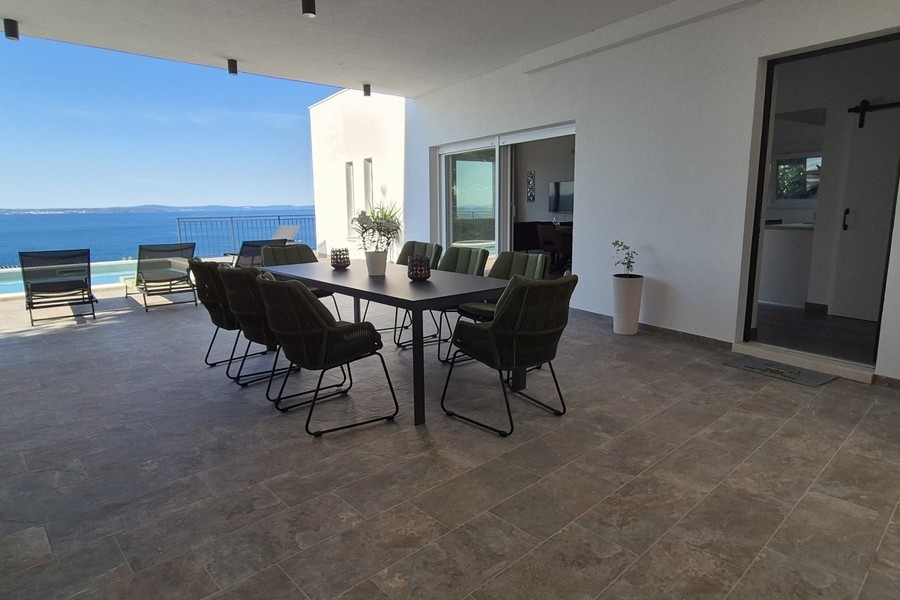 Vaste terrasse avec piscine et espace lounge au bord de la mer