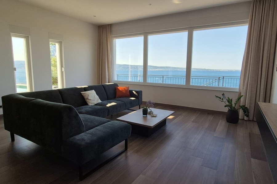 Salon avec grande baie vitrée et vue mer