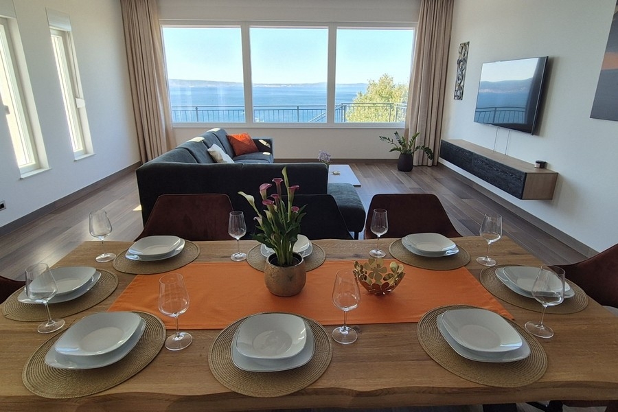 Coin repas avec fenêtres panoramiques et vue sur la côte